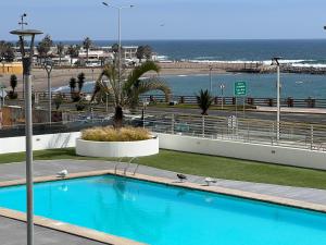 阿里卡Departamento frente al mar en Arica的蓝色的游泳池,背景是大海