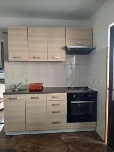 乌马格Apartments by the sea Sveti Ivan, Umag - 7002的厨房配有木制橱柜和炉灶烤箱。