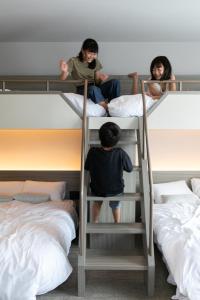 函馆FAV HOTEL HAKODATE的坐在双层床上的一个男孩和一个女孩