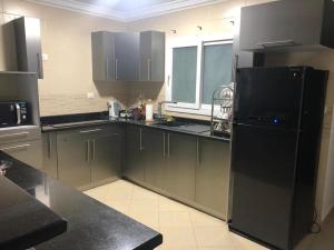开罗Serviced apartment -Sheraton Al Matar (Ocean blue)的厨房配有黑色橱柜和黑色冰箱。