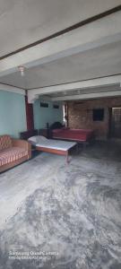 武吉拉旺Lawang Inn的大楼内一间空房间,里面设有沙发和桌子