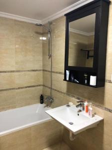 开罗Serviced apartment -Sheraton Al Matar (Ocean blue)的一间带水槽、浴缸和镜子的浴室
