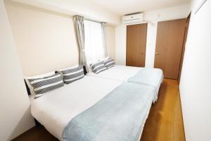 大阪Dio Higashi Shinsaibashi的一间卧室设有两张床和窗户。
