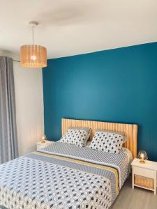 Les CordiersJolie maison de 110 m 2, pour 6 personnes, au calme, avec piscine的一间卧室设有蓝色的墙壁和一张床