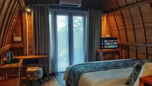 里辛Omah Bapak Ijen Eco House的一间卧室设有一张床和一个大窗户