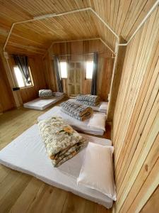 KurseongChimney Farmstay的木制客房内的四张床