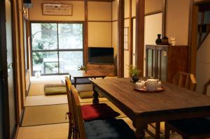 东京Kagurazaka Retro BAR & HOTEL的一间带木桌的客厅和一间餐厅