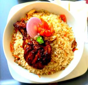 卡尔库达Hotel krish的桌上一碗食物,配以肉和米饭