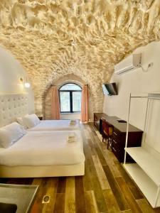 耶路撒冷Petrakis Inn的卧室配有一张白色大床和一张书桌