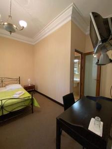 西格纳吉兹维里屋巴尼酒店的配有床、桌子和电视的房间