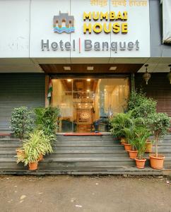 孟买Hotel Mumbai House Juhu, Santacruz West, Mumbai的建筑前有盆栽的旅馆