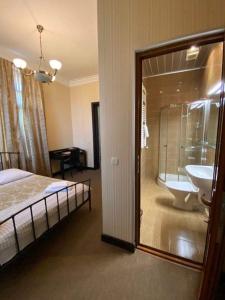 西格纳吉兹维里屋巴尼酒店的一间卧室配有一张床、一个浴缸和一个水槽