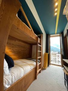 夏蒙尼-勃朗峰Hotel La Verticale的一间卧室设有一张双层床和大窗户。