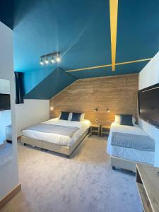 夏蒙尼-勃朗峰Hotel La Verticale的一间卧室设有两张床和蓝色的天花板