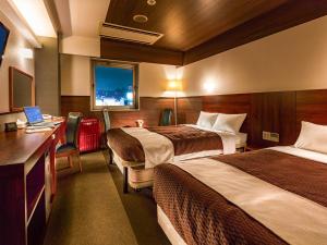 Tokai东海城市酒店的酒店客房配有两张床和一张带笔记本电脑的书桌