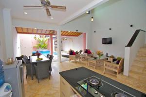 库塔5 Bedroom Holiday Villa - Kuta Regency B8的一间带厨房的客厅和一间餐厅