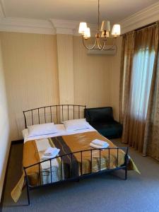 西格纳吉兹维里屋巴尼酒店的一间卧室配有一张大床和一把椅子