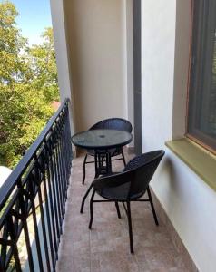 西格纳吉兹维里屋巴尼酒店的阳台配有2把椅子和1张桌子