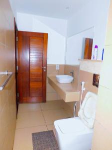 蒙巴萨SWEET BREEZE HOMES的一间带卫生间和水槽的浴室以及一扇木门。