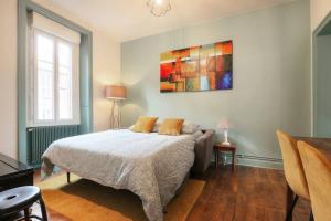 雷恩Le Beaumont的卧室配有一张床,墙上挂有绘画作品