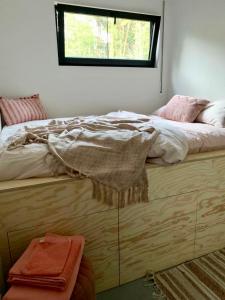LilleOsbos chalets的一间卧室配有一张床铺,上面有窗户