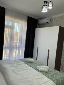 TürkistanKERUEN SARAY APARTMENTS 27/2的一间卧室配有一张床,上面有两条毛巾