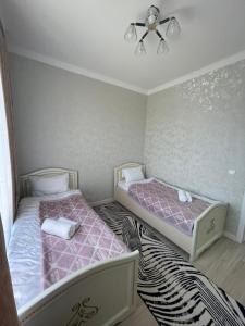 TürkistanKERUEN SARAY APARTMENTS 27/2的粉红色和白色的客房内的两张床
