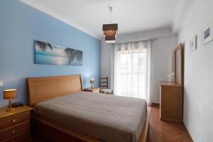 ConceiçãoSol do Algarve的一间卧室设有一张床和蓝色的墙壁