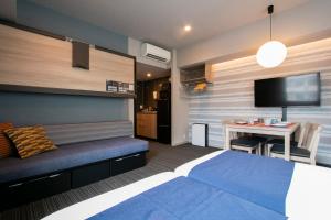 东京Minn Nishi-Kasai的一间卧室配有一张床和一张桌子及电视