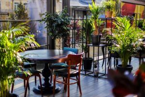 第比利斯Gallery Palace Kosher Hotel的阳台配有桌椅和盆栽植物