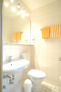 汉诺威豪斯斯帕库勒伽尼酒店的一间带水槽、卫生间和镜子的浴室