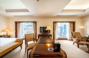胡志明市Lotte Hotel Saigon的配有一张床和一张书桌的酒店客房