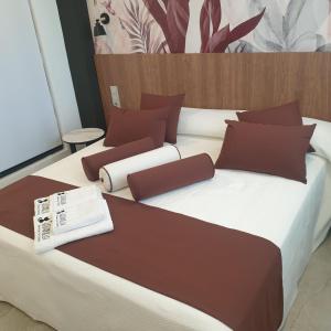 阿尔巴塞特Urbanlux Olimpia Superior的一张大床,配有棕色和白色的床单和枕头