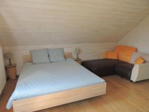 DochampsAuberge "La Fourchette Paysanne"的一间带床和沙发的小卧室