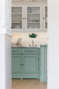 Suir Valley Cottage.的厨房配有蓝色橱柜和水槽