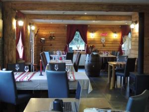 DochampsAuberge "La Fourchette Paysanne"的餐厅内带桌椅的用餐室