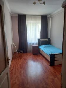 埃里温Malacia apartments的一间铺有木地板的小卧室,配有一张床
