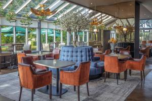 斯拉利Slaley Hall Hotel, Spa & Golf Resort的一间带桌椅和蓝色沙发的餐厅