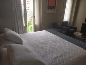 阿尔巴塞特阿尔巴塞特格兰酒店的一间卧室配有一张带窗户和椅子的床