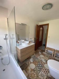 柳奇马约尔Ses Alzines Apartamento integrado en Casa Rural Habitada的带浴缸、水槽和浴缸的浴室