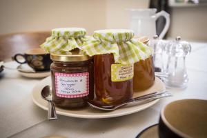 斯基普顿Crown Cottage Farm的桌子上盘子上两罐蜂蜜