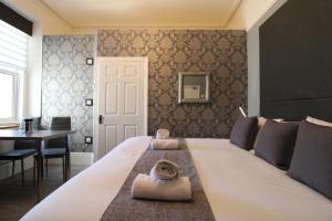 兰迪德诺The Snowdonia Apartments的卧室配有一张白色的大床和一张桌子