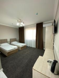 塔拉兹Sapphire hotels的酒店客房设有两张床和电视。