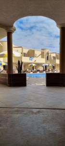 杰迪代Hotel Beach Club la Perle的享有带游泳池和遮阳伞的建筑景致
