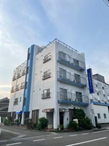 那智胜浦町MAGURO BLDG チェックインはWhyKumano的街道边的白色大建筑