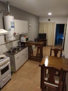 里奥夸尔托Departamento amoblado Rio Cuarto的厨房配有桌子、炉灶和桌子。