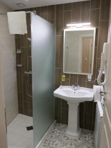 多瑙河畔伊布斯Hotel MEDITERRANEO的浴室配有盥洗盆和带镜子的淋浴