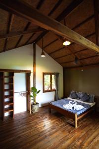 爱妮岛Fisheye Villa的铺有木地板的客房内设有一间卧室和一张床。