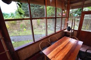 爱妮岛Fisheye Villa的窗户间里的一张木桌和椅子
