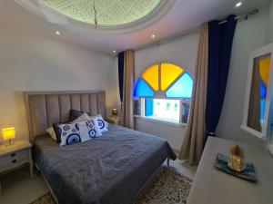 杰尔吉斯Villa Bleue plage Sonia的一间卧室设有一张床和一个大窗户
